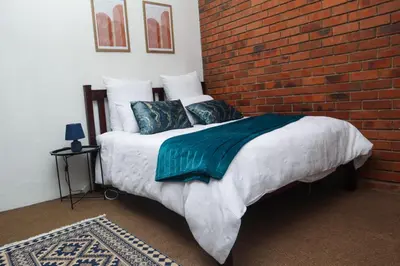 a bed in a room with a brick wall at Spacious and luxury 3 bedroom apartment in Midrand