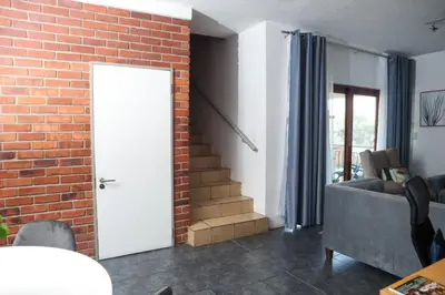 a living room with a brick wall and a door at Spacious and luxury 3 bedroom apartment in Midrand