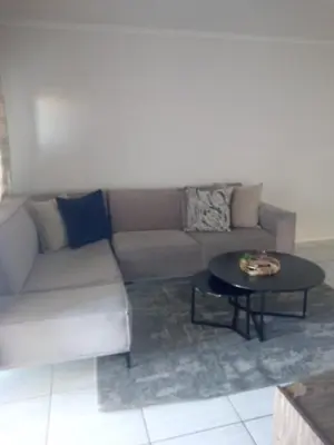 a living room with a couch and a table at Large 3 Bedroom Apartment in Midrand, Waterfall City - More space than a hotel room - Ideal for families, groups and work trips - 19 Elizabeth Place in Midrand