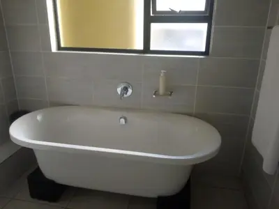 a white bath tub in a bathroom with a window at Large 3 Bedroom Apartment in Midrand, Waterfall City - More space than a hotel room - Ideal for families, groups and work trips - 19 Elizabeth Place in Midrand
