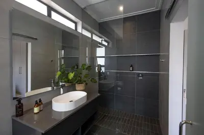 a bathroom with a sink and a shower at Luxurious Upmarket Apartment in Pretoria