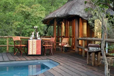 a wooden deck with a table and chairs and a hut at Makweti Safari Lodge in Welgevonden Game Reserve