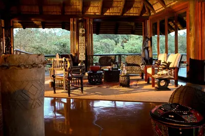 a living room with rocking chairs on a porch at Makweti Safari Lodge in Welgevonden Game Reserve