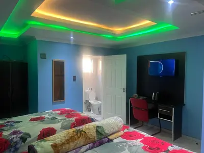 a bedroom with a bed with green lights on the ceiling at Goldwell airport Lodge in Kempton Park
