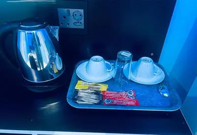 a tray with two dishes and a coffee maker at Goldwell airport Lodge in Kempton Park