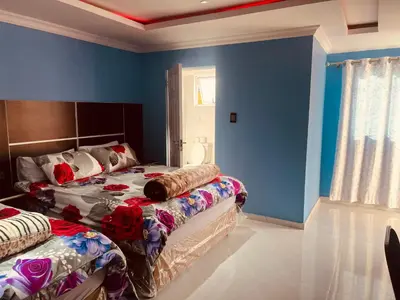 two beds in a room with blue walls at Goldwell airport Lodge in Kempton Park