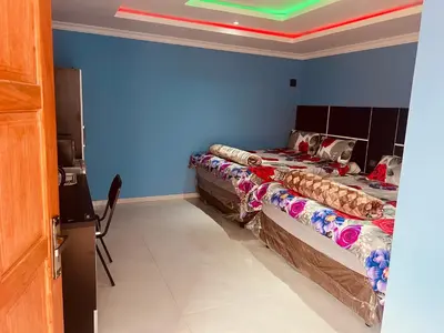 two beds in a room with blue walls at Goldwell airport Lodge in Kempton Park