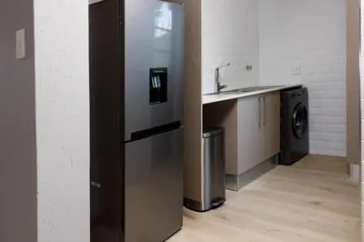 a stainless steel refrigerator in a kitchen with a sink at Uptown Apartments - Garden Pavillion in Nelspruit