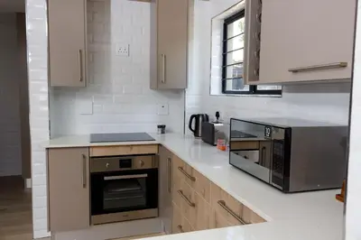 a kitchen with a stove and a microwave at Uptown Apartments - Garden Pavillion in Nelspruit