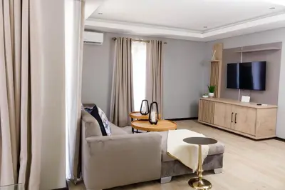 a living room with a couch and a tv at Uptown Apartments - Garden Pavillion in Nelspruit