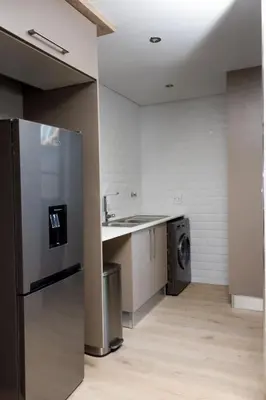 a kitchen with a refrigerator and a washing machine at Uptown Apartments - Garden Pavillion in Nelspruit