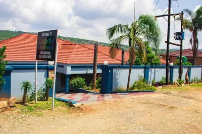 a sign in front of a building with palm trees at Lizpeter guest house in Elim