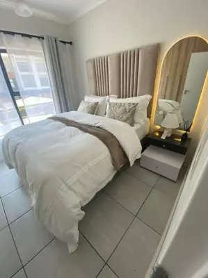 a bedroom with a large bed with a large mirror at One Bedroom The Blyde in Pretoria