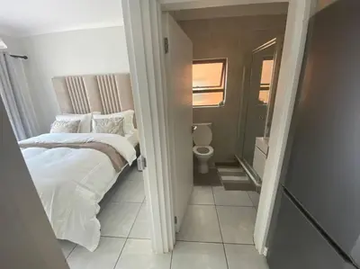 a small bedroom with a bed and a toilet at One Bedroom The Blyde in Pretoria