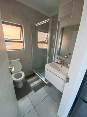 a bathroom with a toilet and a shower and a sink at One Bedroom The Blyde in Pretoria