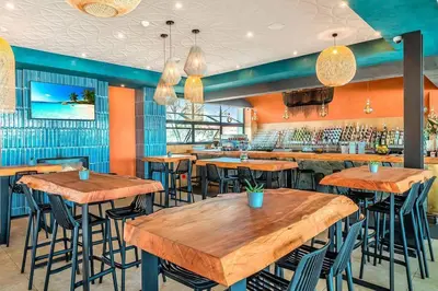 a restaurant with wooden tables and bar stools at One Bedroom The Blyde in Pretoria