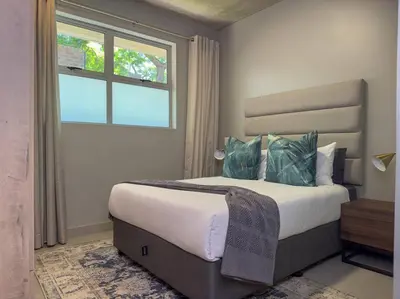 a bedroom with a large bed and a window at Seed @Colette in Pretoria