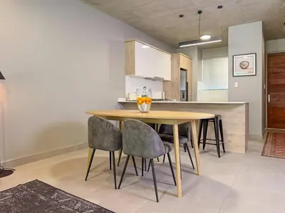a kitchen with a wooden table and chairs at Seed @Colette in Pretoria