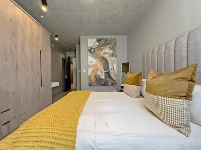 a bedroom with a large white bed with yellow pillows at Seed @Colette in Pretoria