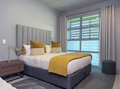 a bedroom with a large bed with a large window at Seed @Colette in Pretoria