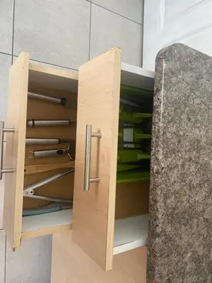 a wooden cupboard with ajar doors in a kitchen at Mamuka Africa in Midrand