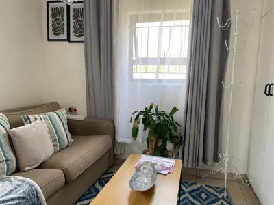 a living room with a couch and a table at Mamuka Africa in Midrand