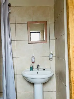 a bathroom with a sink and a mirror at Wampi guesthouse in Polokwane