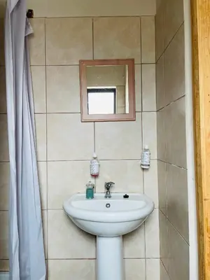 a bathroom with a sink and a mirror at Wampi guesthouse in Polokwane