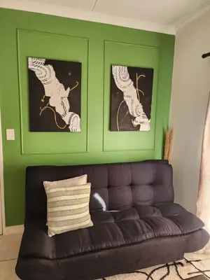 a green living room with a black leather couch at 297 The Blyde Crystal Lagoon in Pretoria