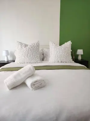 a white bed with white pillows and towels on it at 297 The Blyde Crystal Lagoon in Pretoria