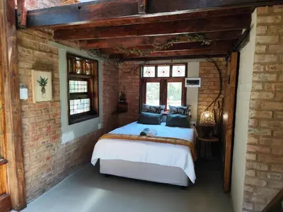 a bedroom with a bed in a brick wall at Bethesda Mountain Lodge in De Wildt