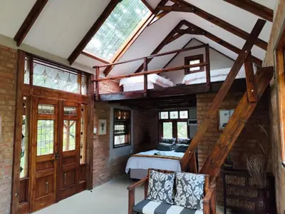 an attic bedroom with a bed and a loft at Bethesda Mountain Lodge in De Wildt