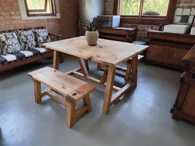 a wooden table and bench with a potted plant on it at Bethesda Mountain Lodge in De Wildt