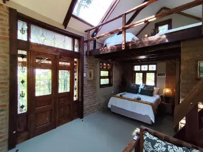 a bedroom with a bed and a loft at Bethesda Mountain Lodge in De Wildt