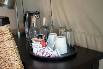 a table with a tray with cups and other items on it at Mapesu Wilderness Tented Camp in Musina