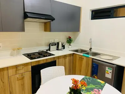 a small kitchen with a table and a sink at Nelly`s Green Creek Luxury Apartment in Pretoria