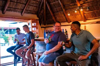 a group of men sitting at a bar drinking at The Hemingway House 14 Resort Pool in Benoni