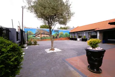 a courtyard with a tree and a building at The Hemingway House 14 Resort Pool in Benoni