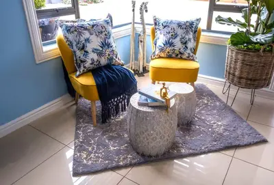 a living room with a yellow chair and a table at The Hemingway House 14 Resort Pool in Benoni