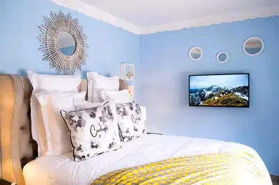 a bedroom with a bed with a tv on the wall at The Hemingway House 14 Resort Pool in Benoni