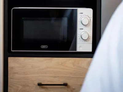 a microwave oven sitting on top of a wooden table at Brooklyn Blok in Pretoria