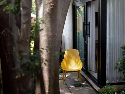 a yellow chair sitting on a porch next to a tree at Brooklyn Blok in Pretoria