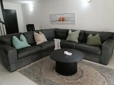 a living room with a couch and a table at Beautiful apartment behind Illanga Mall in Mataffin
