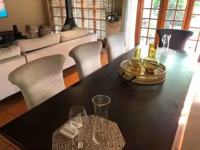 a black table with two bottles and chairs in a living room at Airbnb at Bailyes in Pretoria