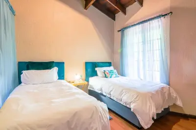 two beds in a room with a window at Airbnb at Bailyes in Pretoria