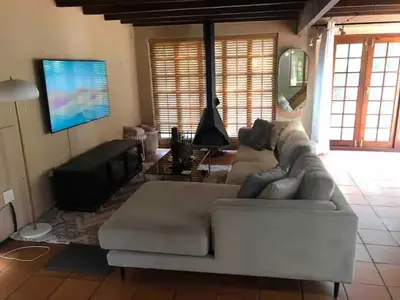 a living room with a couch and a flat screen tv at Airbnb at Bailyes in Pretoria