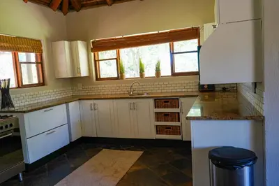 a kitchen with white cabinets and a sink at Lucca House in Musina