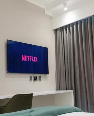 a television in a room with a netflix sign on the wall at The Trilogy Apartment MM 51011 in Pretoria