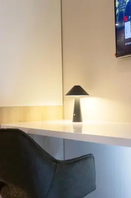 a desk with a black lamp and a chair at The Trilogy Apartment MM 51011 in Pretoria