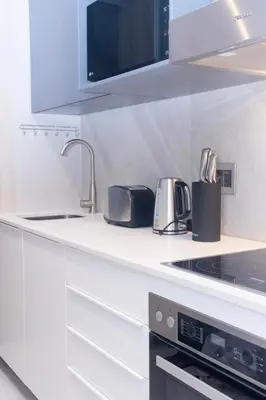 a white kitchen with a sink and a stove at The Trilogy Apartment MM 51011 in Pretoria